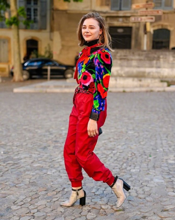 Chloë Grace Moretz attends a fashion show in Paris, wearing a colorful outfit.