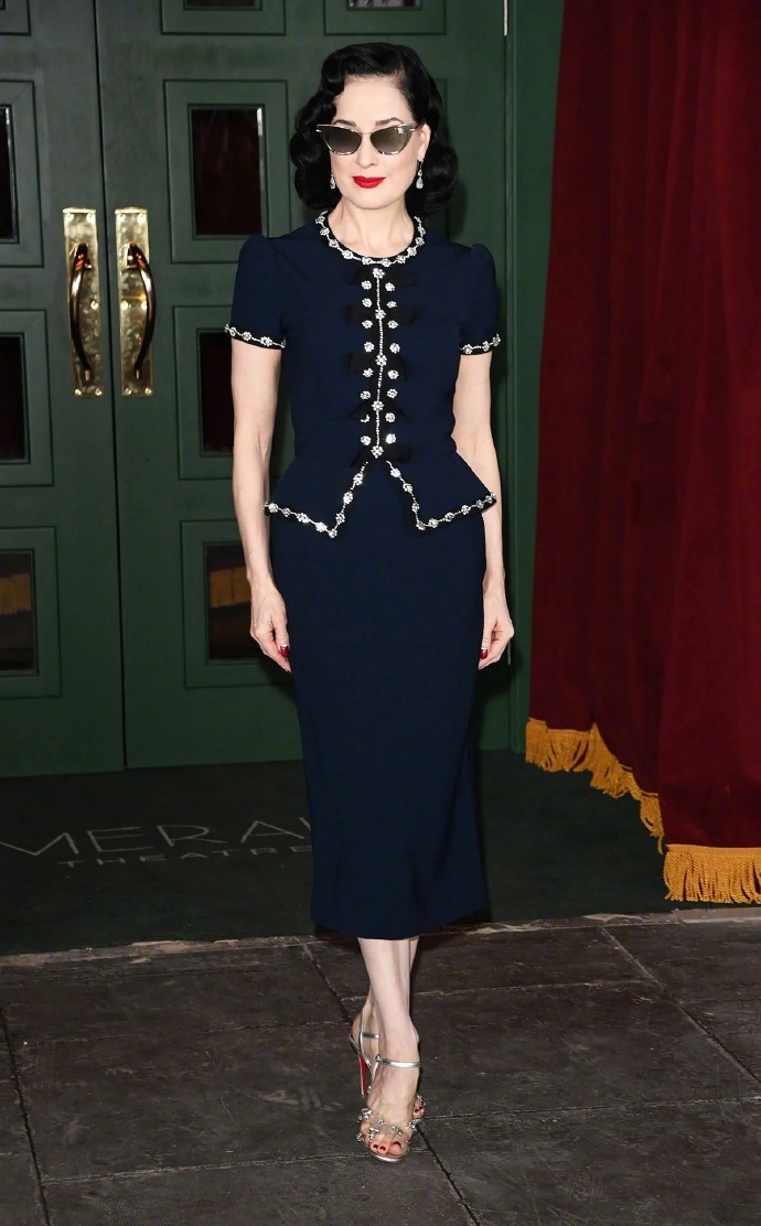 Dita Von Teese wears a custom navy dress from Jenny Packham