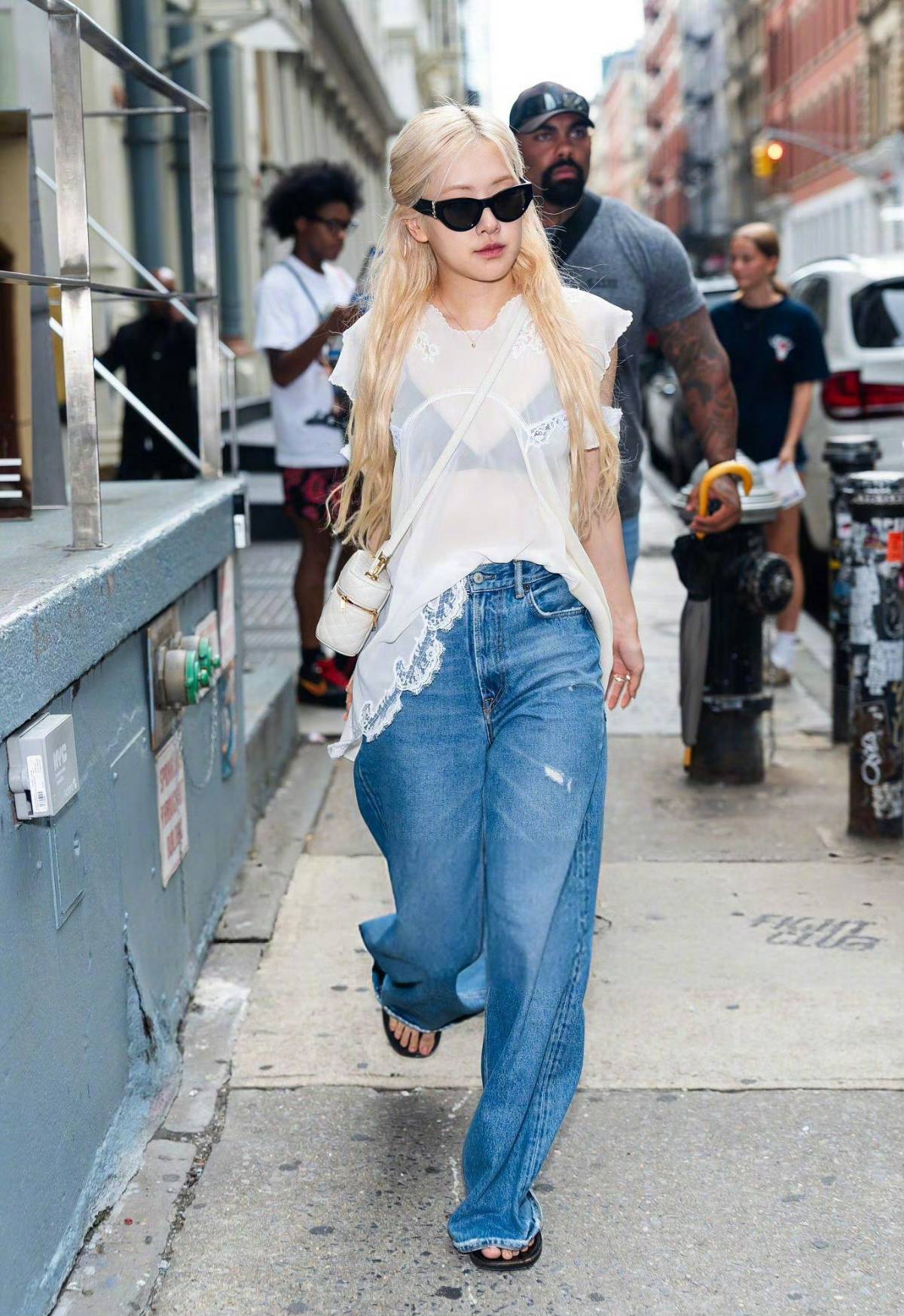 Rosé in white sheer lace top and wide-leg jeans