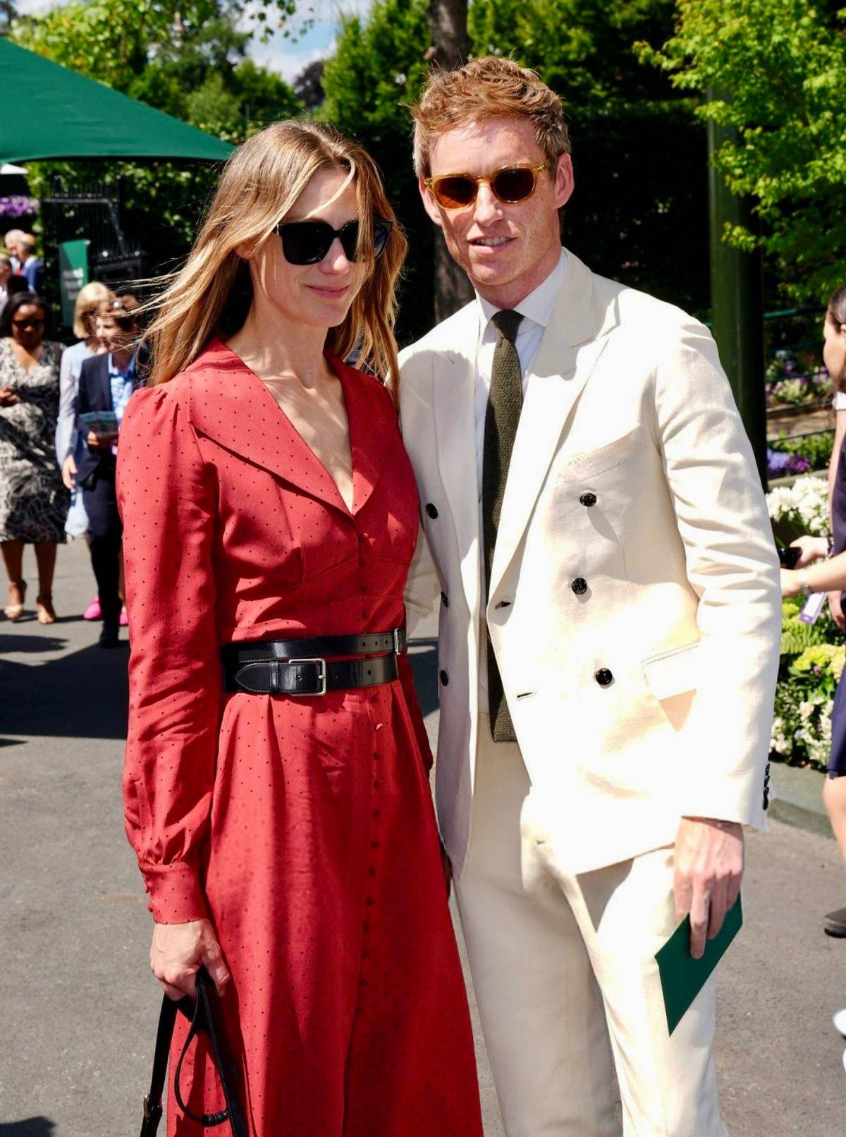 Eddie Redmayne (double-breasted suit) and Hannah (stylish red dress) at Wimbledon
