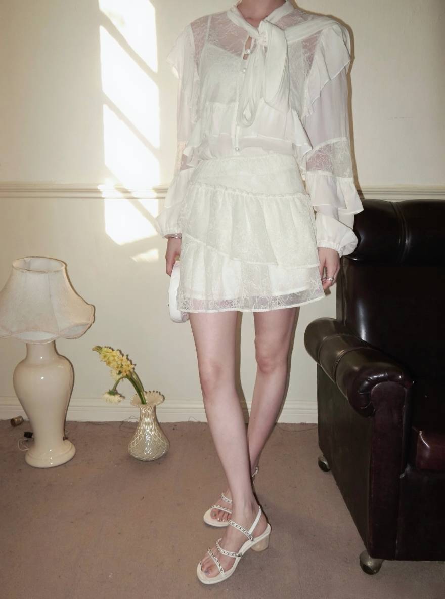 Elegant sheer blouse paired with lace skirt