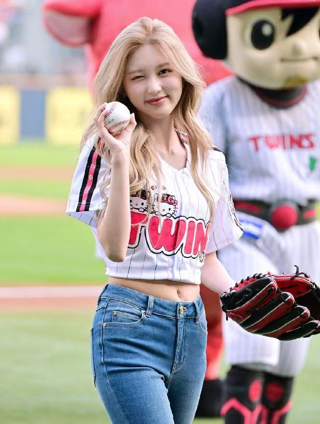 Wearing a Hello Kitty baseball jersey, she winked with a radiant smile.