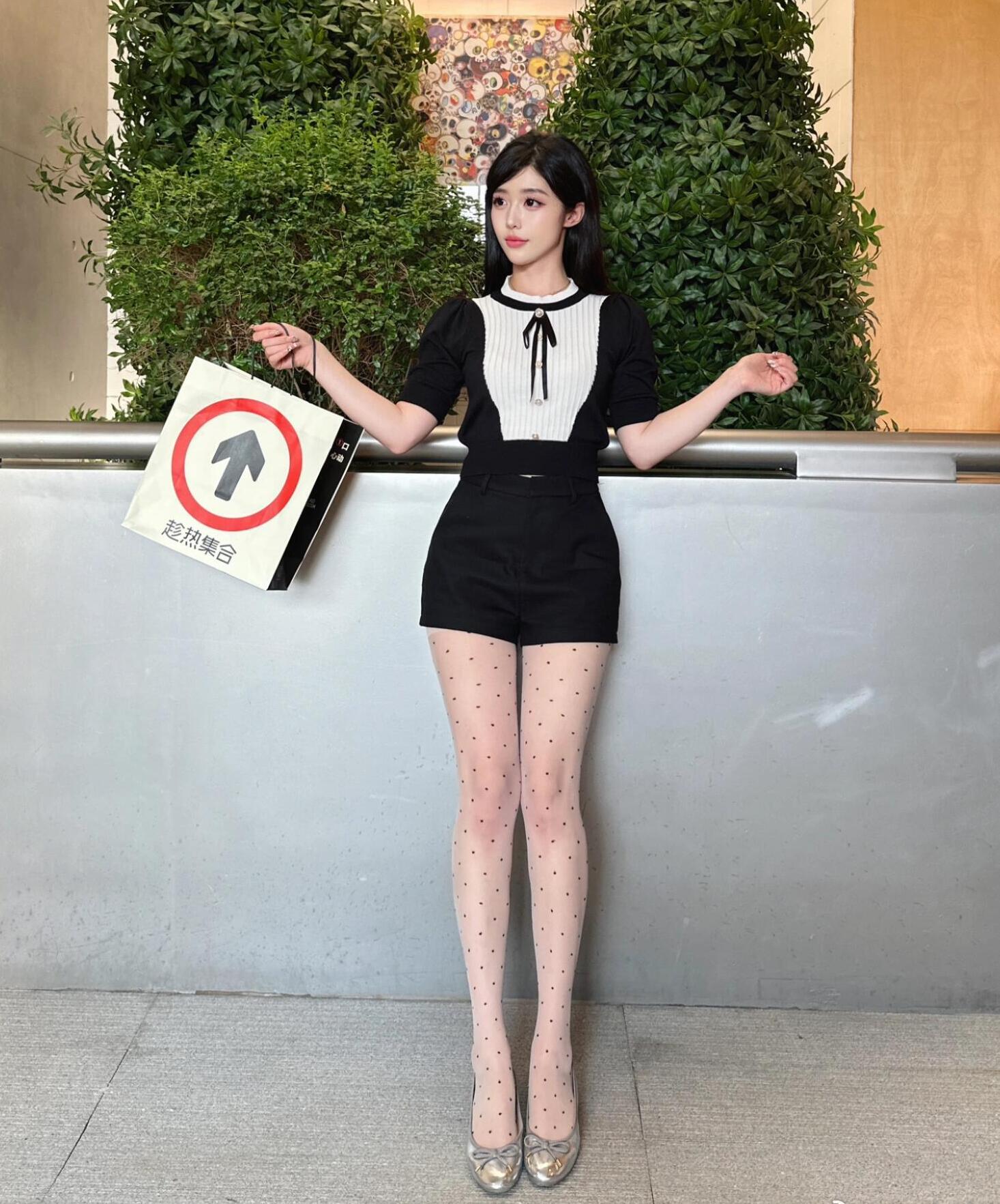 A chic girl dressed in stylish shorts and polka dot tights.