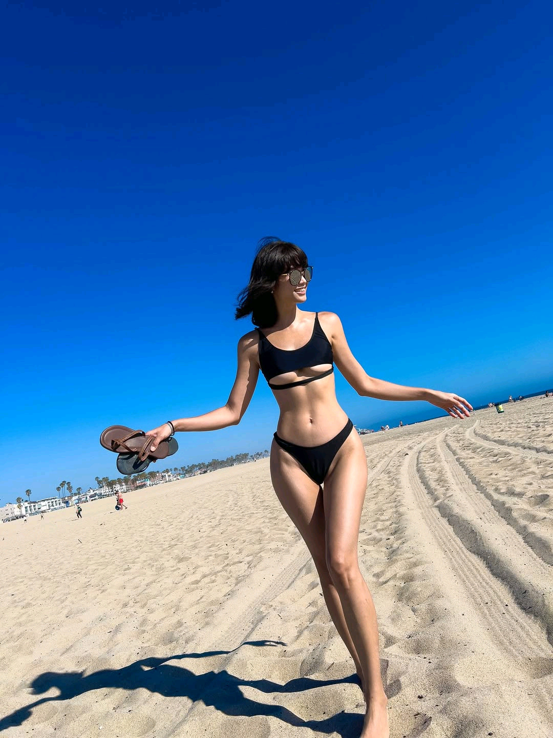 Leeheeeun wearing a black two-piece swimsuit at the beach