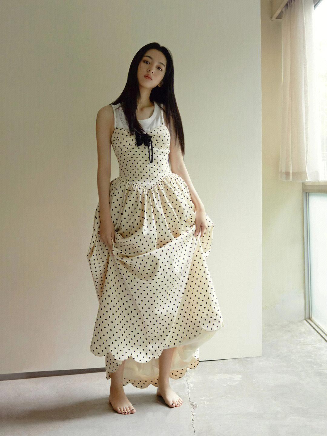 A sleeveless polka dot dress layered over a white camisole.