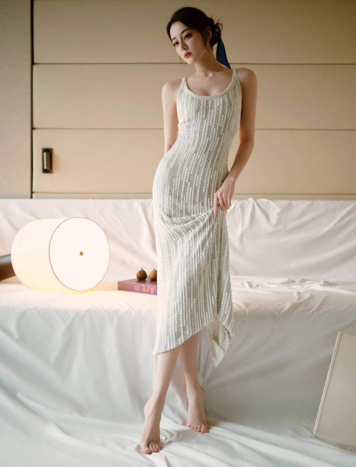 A sleeveless white knit maxi dress with a vertical ribbed texture.