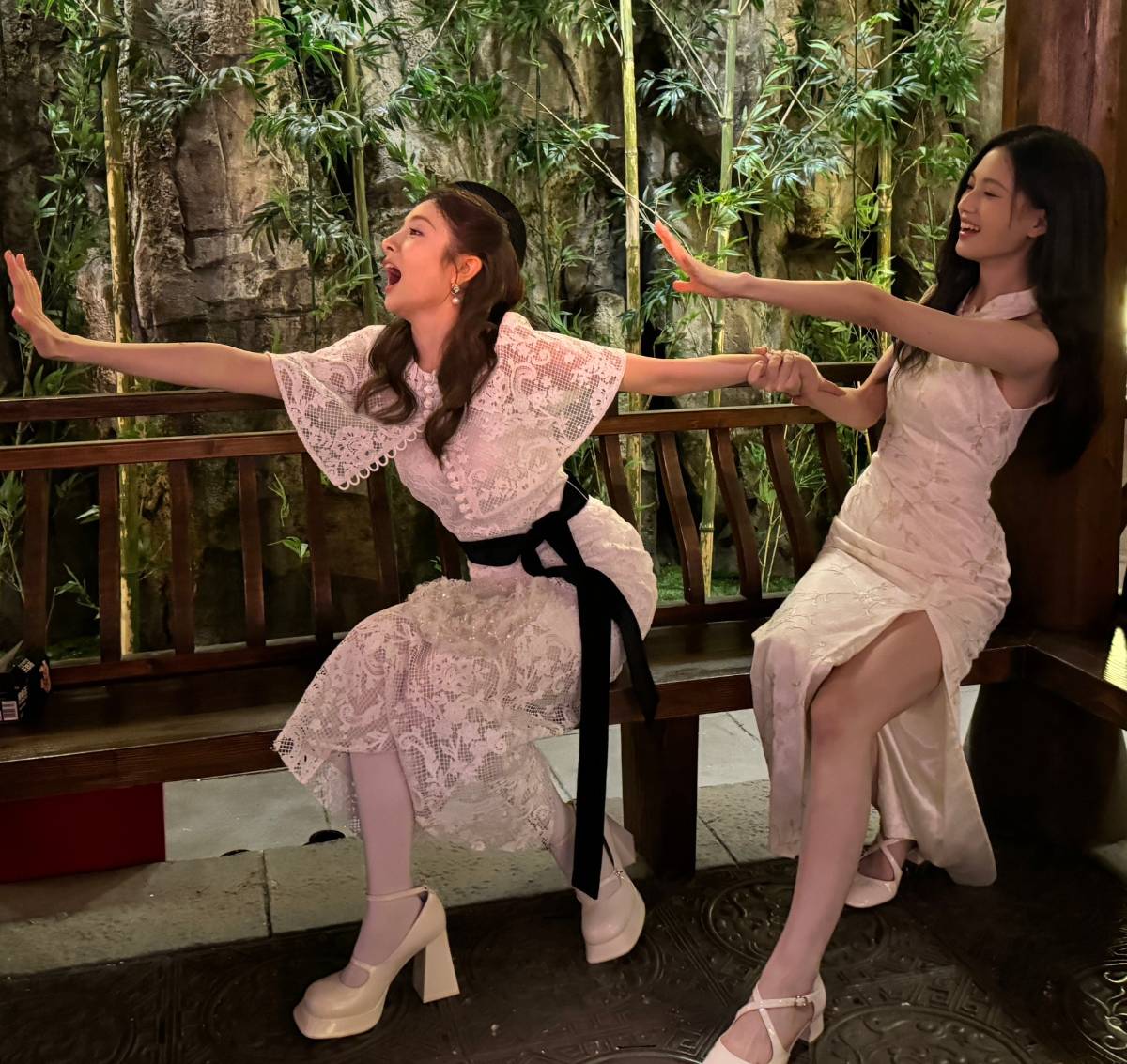 Two funny beauties, one wearing a lace dress and the other wearing a slit dress