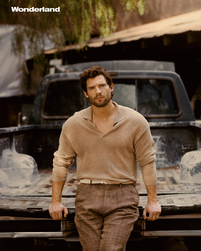 David Corenswet wearing sweater and trousers photo review