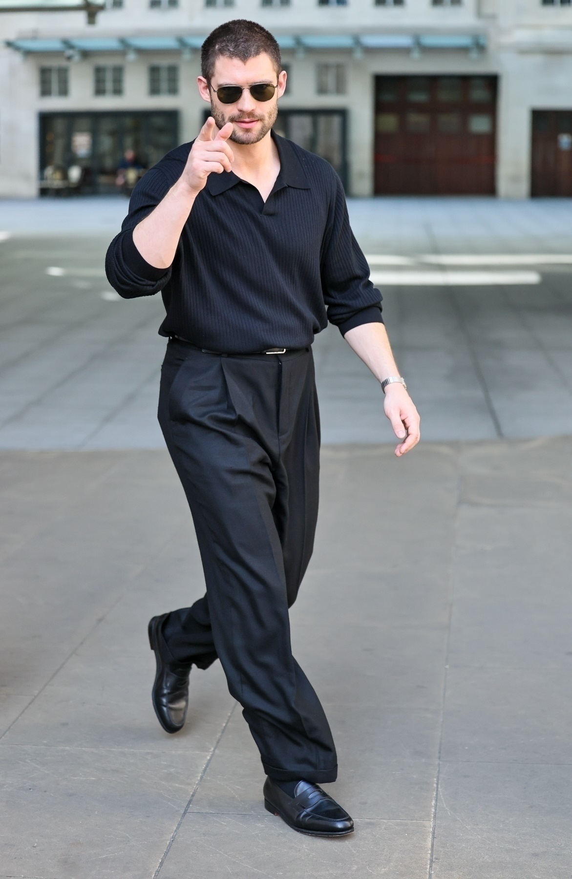 David Corenswet wears a polo shirt and pleated trousers.