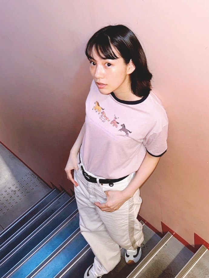 NON on the stairs, wearing graphic t-shirt paired with cargo pants