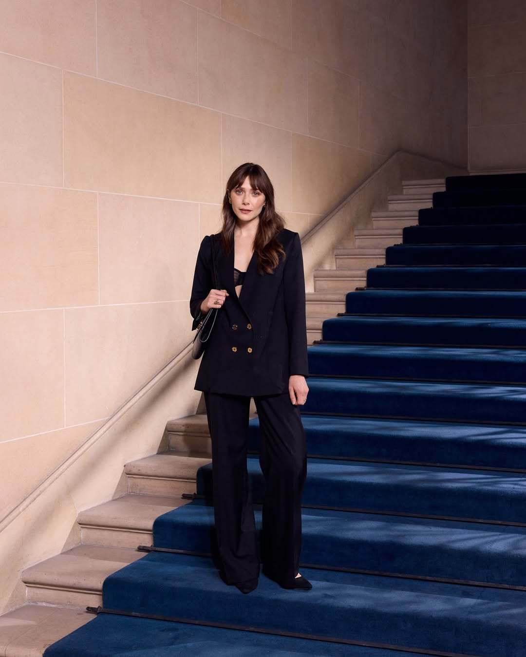 Elizabeth Olsen in a Sleek Navy Power Suit at the Grand Staircase
