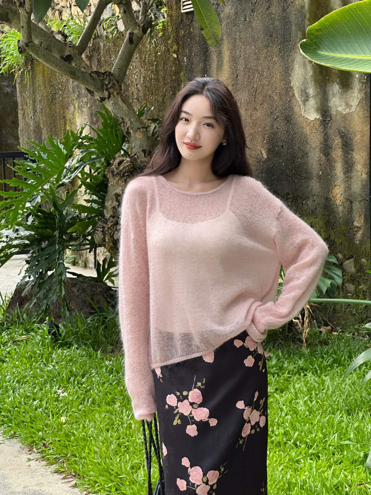 A soft pink woolen sweater paired with black floral skirt