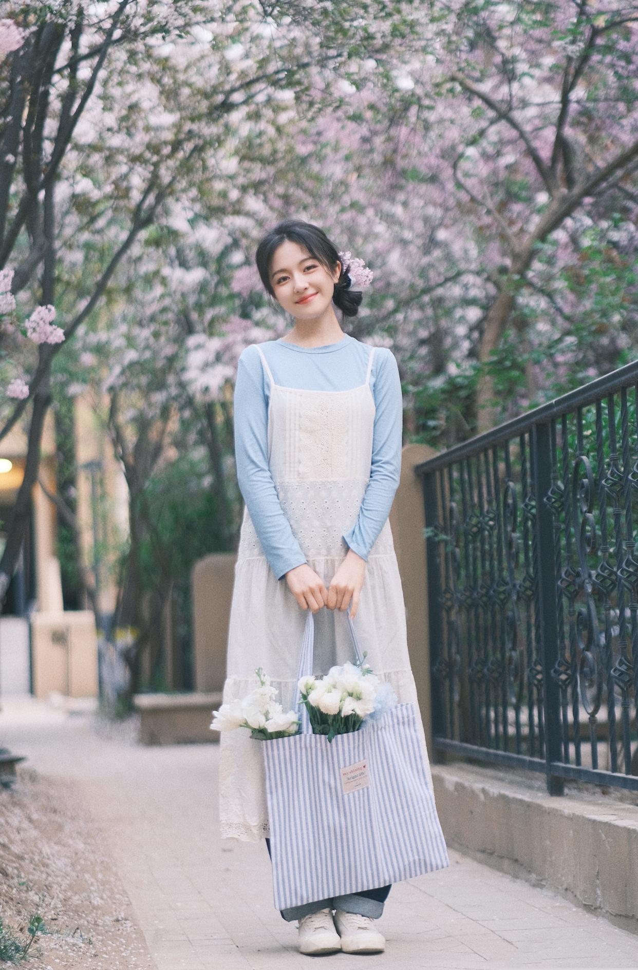 A cute girl in white suspender midi dress and blue long-sleeve shirt