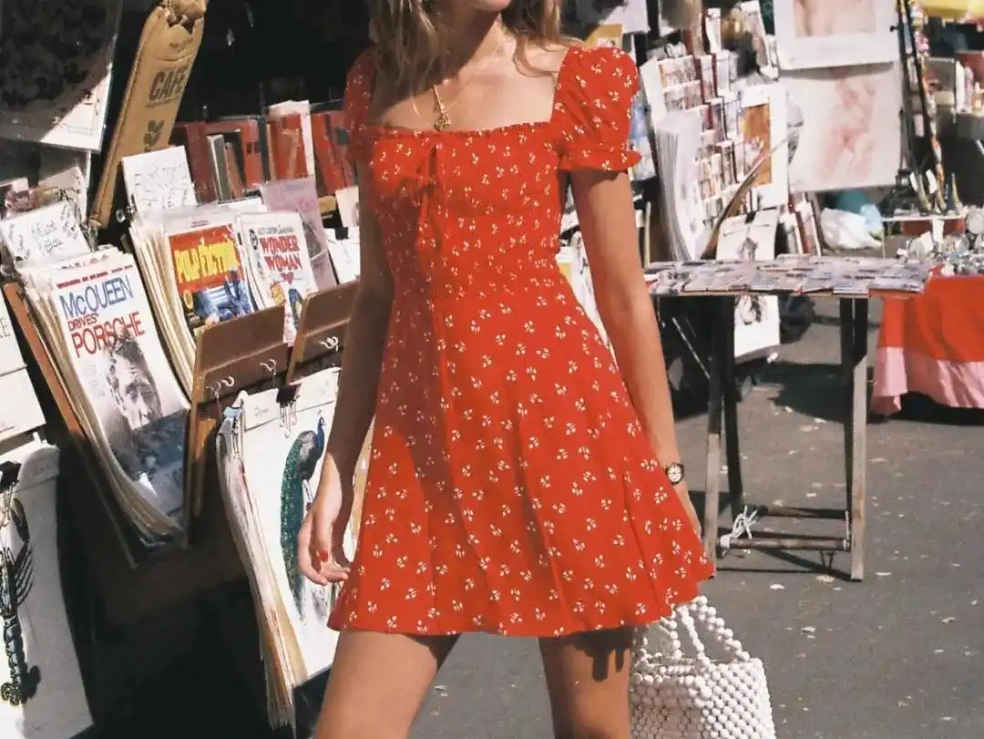 A vibrant summer floral dress, a red dress adorned with small white flowers.