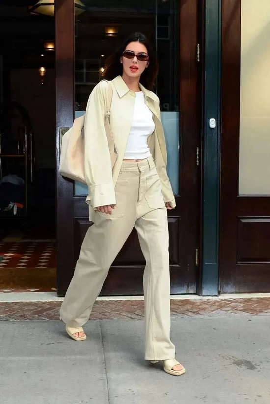 Kendall Jenner rocked a white tank top layered with a beige overshirt and matching wide-leg pants — stylish and effortlessly cool.