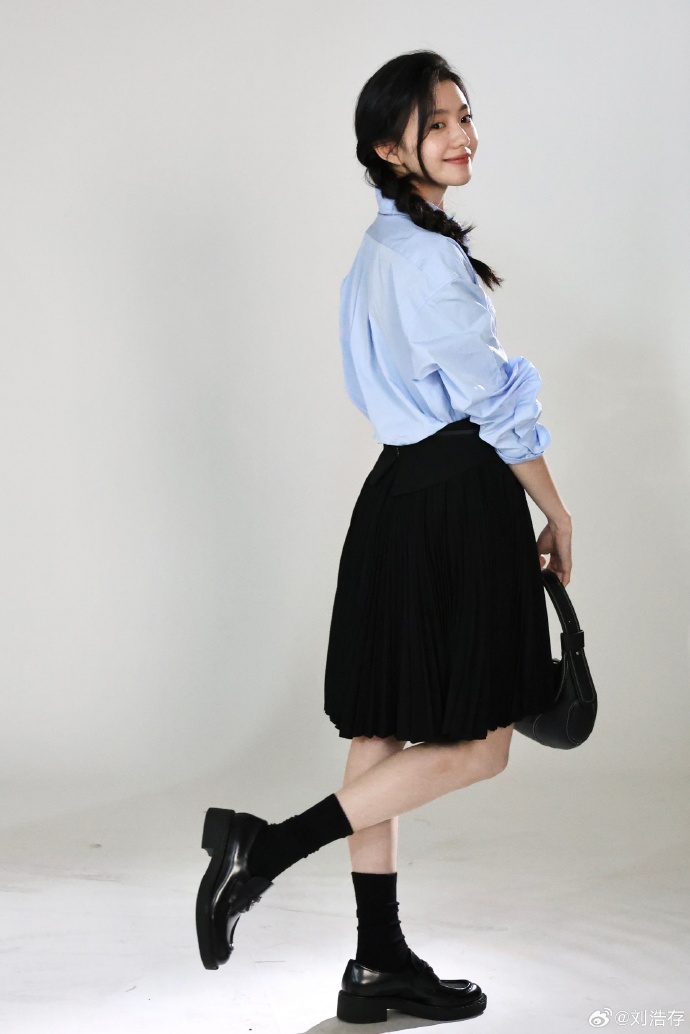 Light blue shirt paired with a black skirt and black leather shoes.