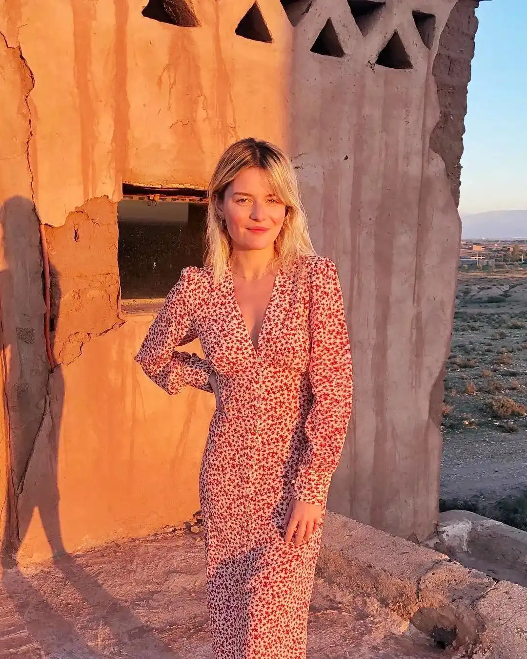 Beauty in the sunset: a blonde girl in a deep V-neck floral dress.