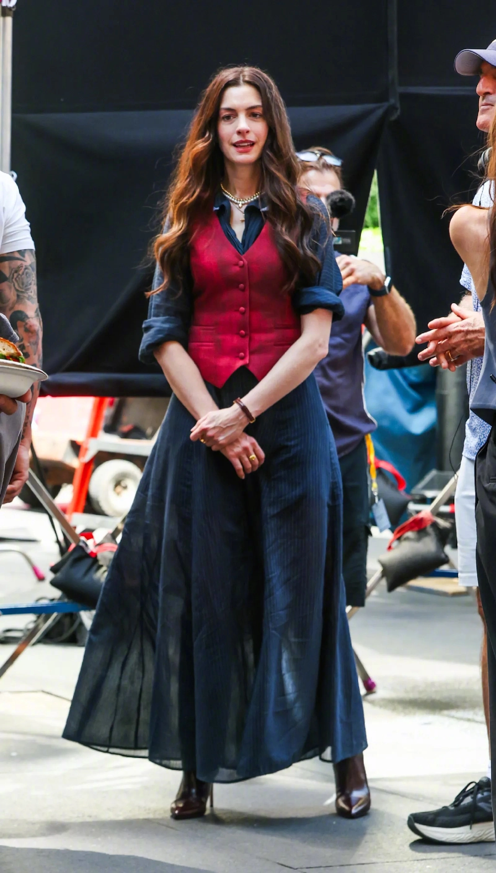 Anne Hathaway's look in "The Devil Wears Prada 2": Elegant Red Waistcoat and Flowing Dark Skirt Ensemble