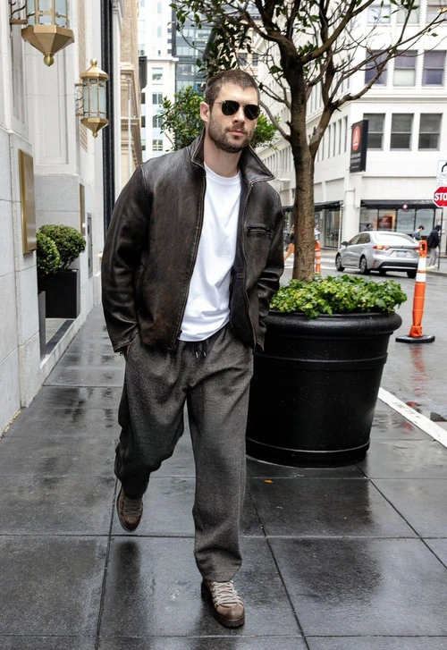 Rugged Brown Leather Jacket with Relaxed Gray Pants and Casual White Tee
