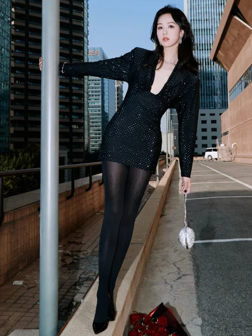 Elegant Black Mini Dress with Embellishments and Sheer Tights for a Chic Evening Look