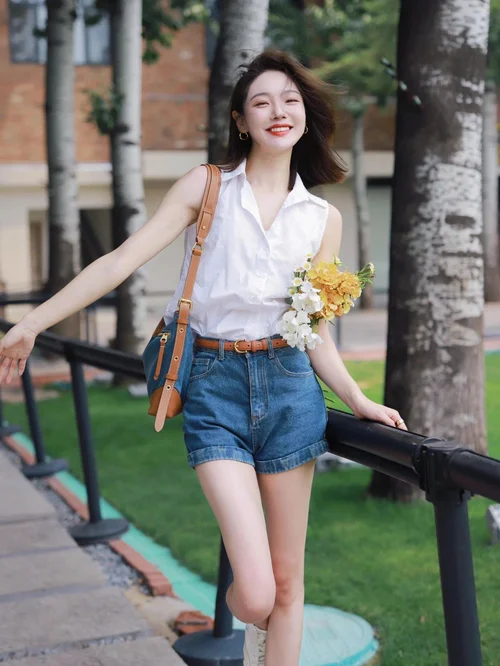 Chic Summer Ensemble: White Sleeveless Blouse with Denim Shorts and Tan Accessories