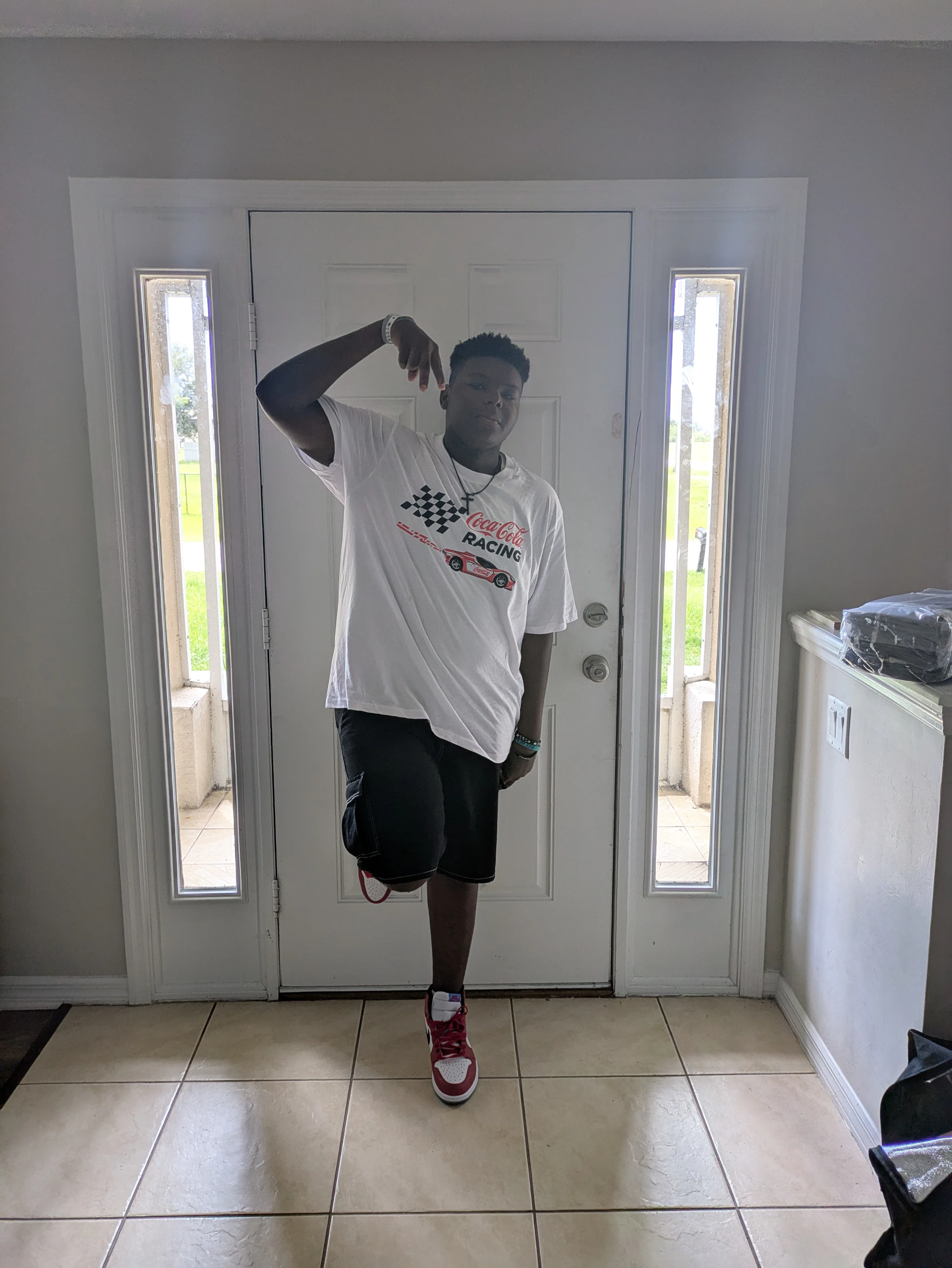 Casual Sporty Style Featuring Graphic T-Shirt, Black Shorts, and Red Sneakers