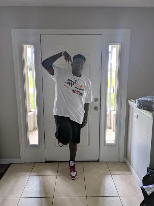 Casual Sporty Style Featuring Graphic T-Shirt, Black Shorts, and Red Sneakers