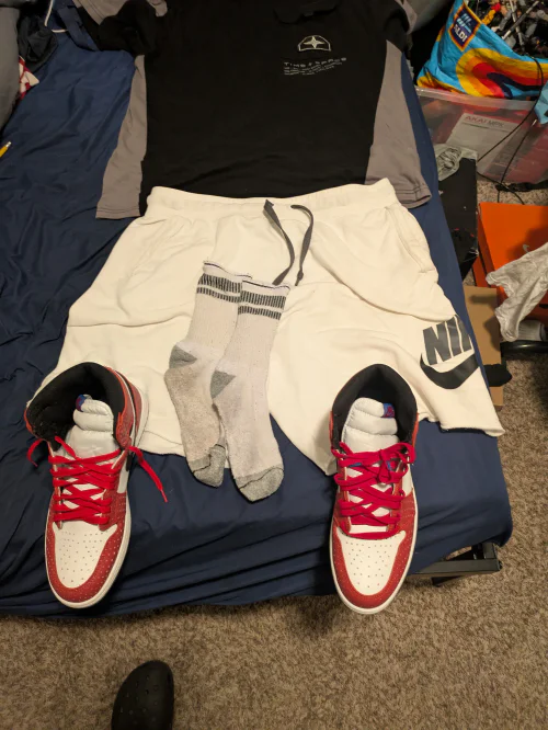 Sporty Casual Outfit with Black and Gray Top, White Nike Shorts, and Red Sneakers