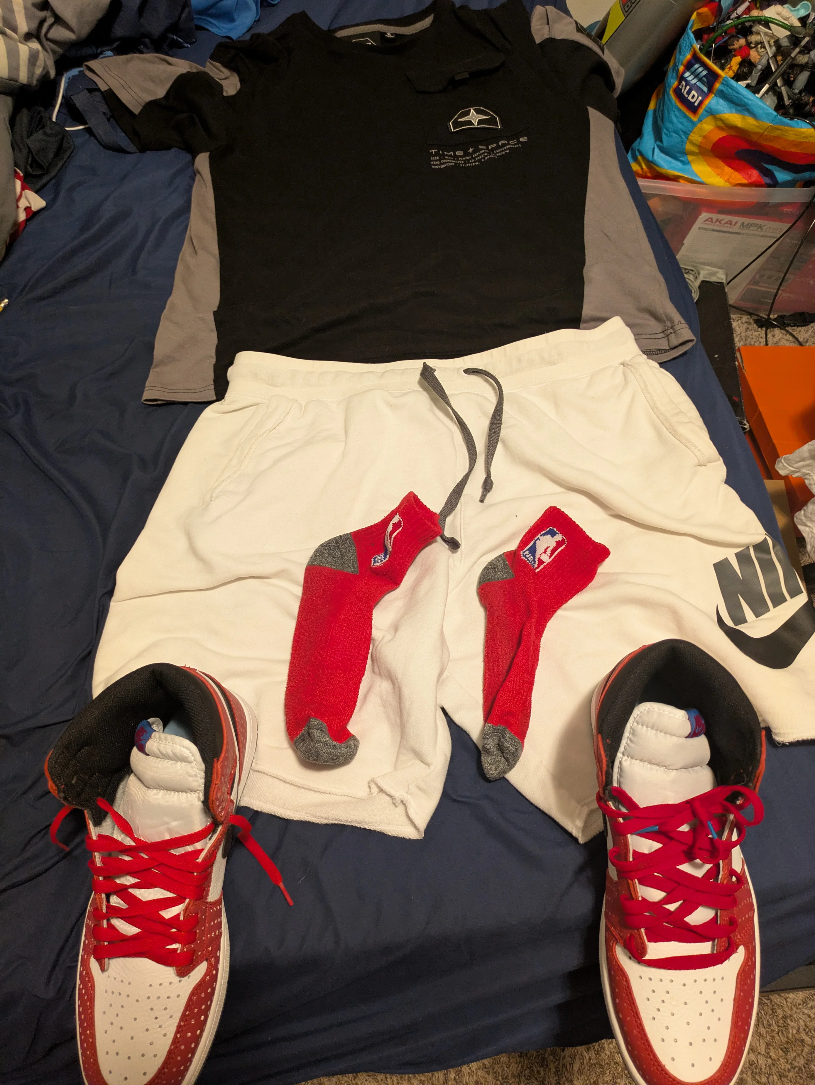 Sporty Chic: Black and Gray Athletic Shirt with White Nike Shorts and Red Accented Sneakers