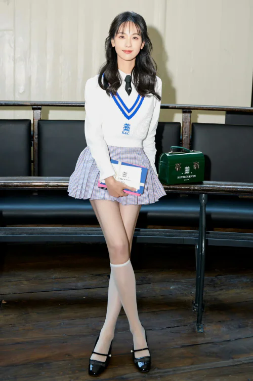 Preppy Chic: White Sweater, Plaid Skirt, and Green Handbag Style