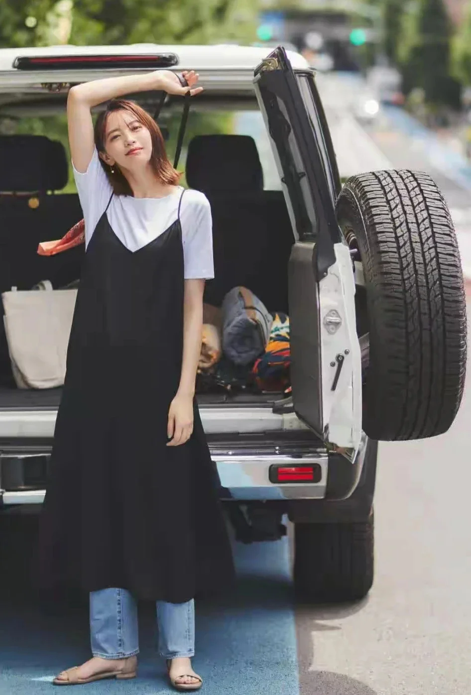 Stylish Layering with Black Slip Dress Over White T-Shirt and Jeans