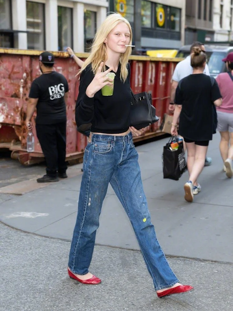 Casual Street Style: Black Top, Blue Jeans, and Bold Red Shoes