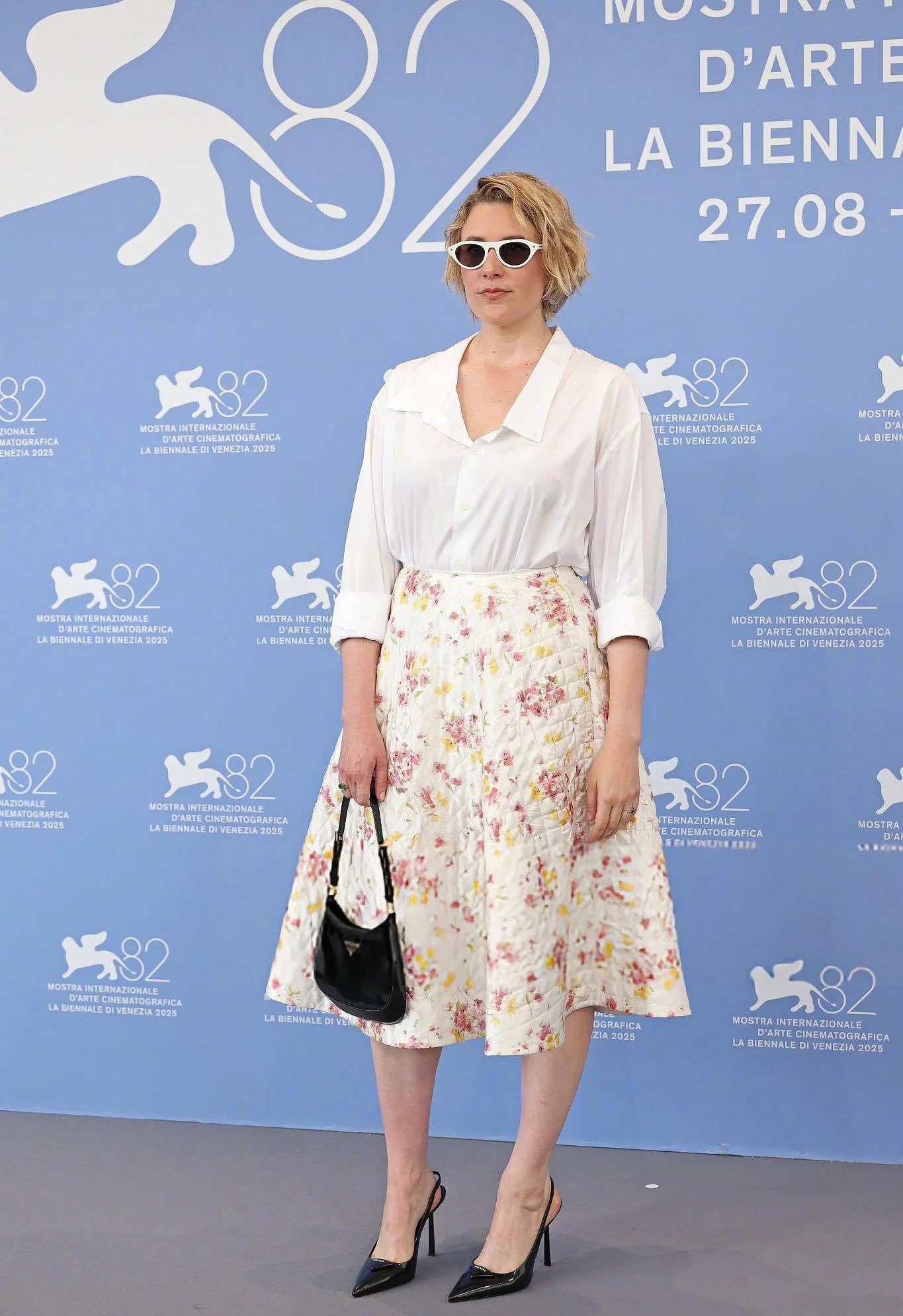 Elegant White Blouse and Floral Midi Skirt Ensemble with Black Accessories