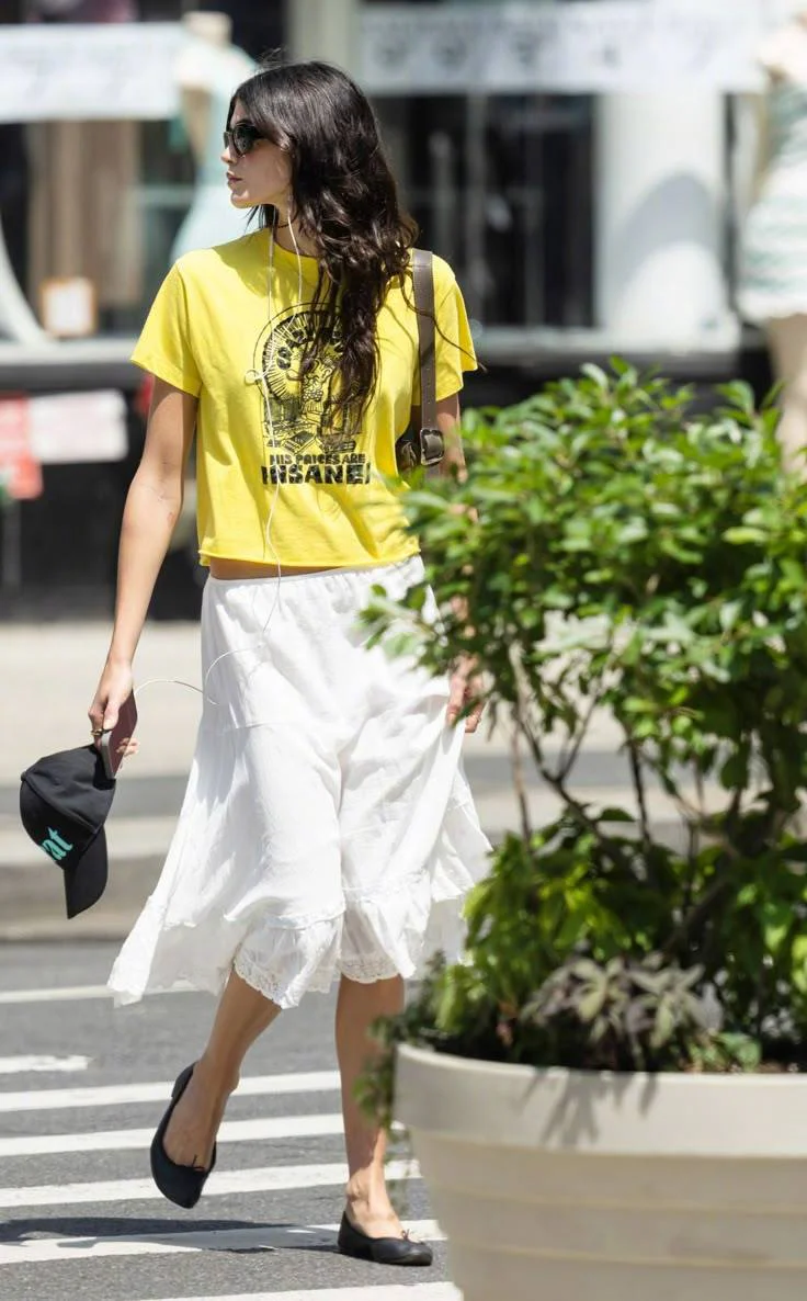 Kaia Gerber Street Style. Vibrant Yellow Tee with White Skirt for a Casual Summer Look