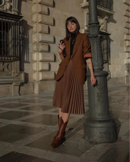 Elegant Monochromatic Brown Outfit with Pleats and Cowboy Boots for a Modern Classic Look