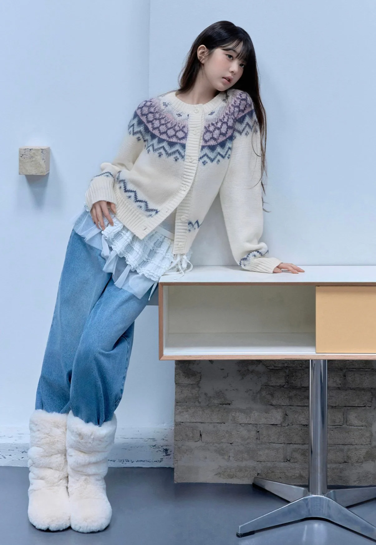 Cozy Winter Style: Cream Patterned Cardigan, Denim Jeans, and Fluffy Boots