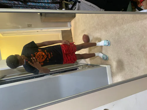 Casual Black T-shirt and Red Shorts Paired with Slides for a Relaxed Look