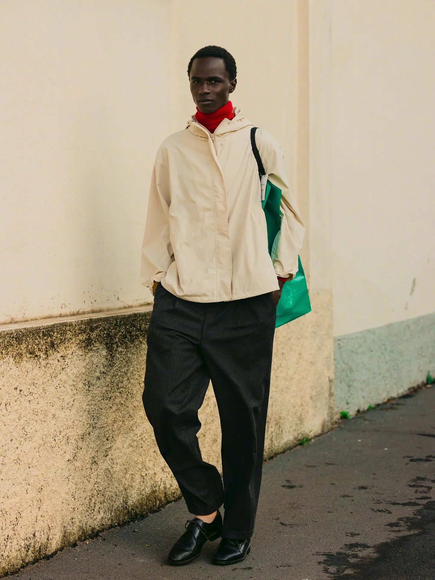 Contemporary Style with a Pop of Red and Green; Off-White Windbreaker, Red Turtleneck, and Black Trousers