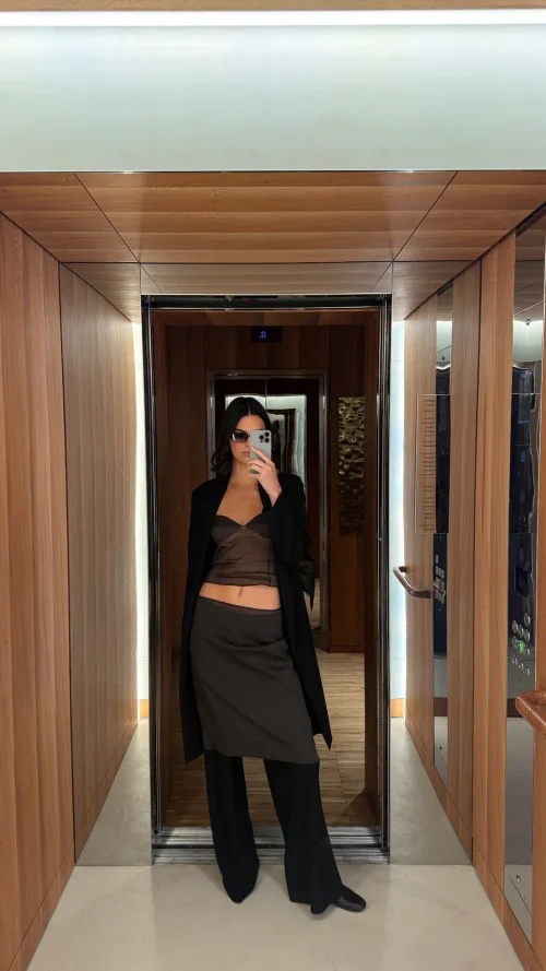 Modern Layered Elegance: Sheer Brown Top with Black Layered Bottoms and Coat