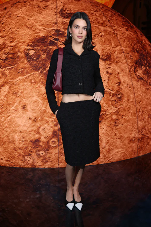 Kendall Jenner OOTD. Stylish Black Ensemble with Cropped Jacket and Midi Skirt Paired with Pointed Shoes