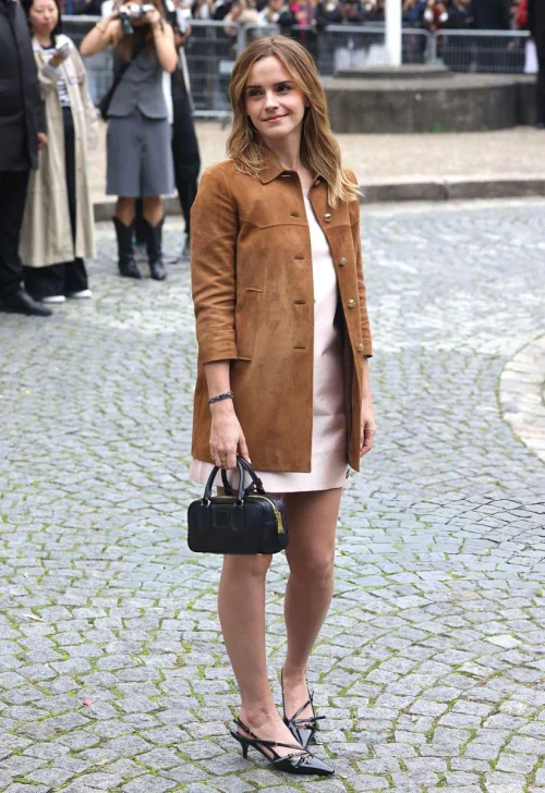 Emma Watson at Paris Fashion Week. Elegant Camel Coat with White Mini Dress and Black Accents