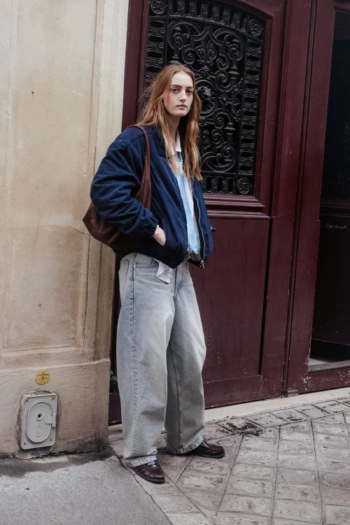 Chic Casual Style: Navy Bomber Jacket with Light-Wash Baggy Jeans and Leather Shoes