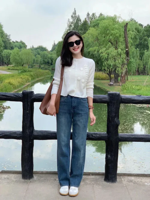 Casual Chic: White Sweater and Blue Jeans Combo with Brown Accessories