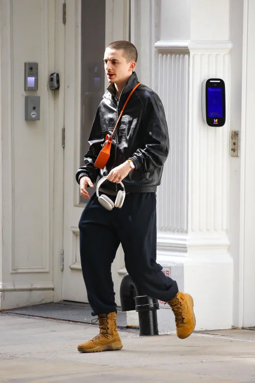 Casual Edginess: Leather Jacket Paired with Tan Boots and Accents of Orange