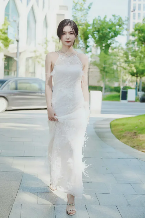 Elegant White Halter-Neck Floral Gown with Feather Details and Minimalist Accessories