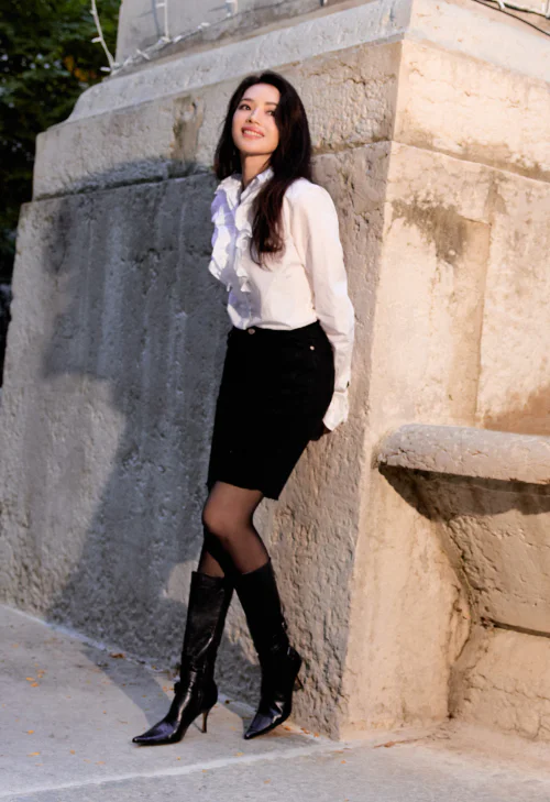 Elegant White Ruffled Blouse and Black Skirt with Sleek Leather Boots