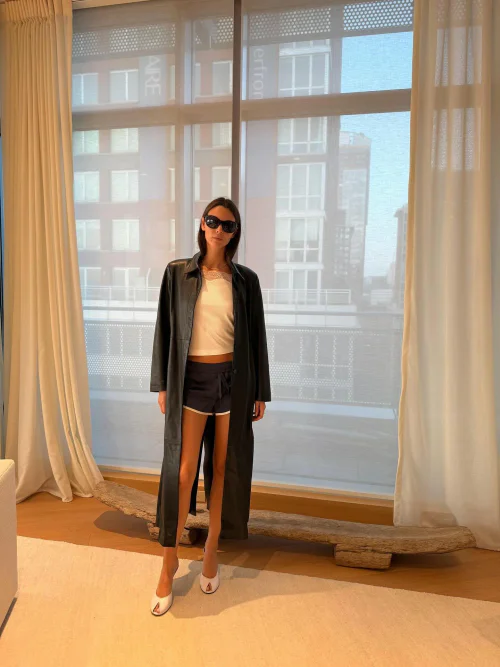 Vittoria Ceretti OOTD. Sleek Dark Coat with Casual Shorts and White Accents for Urban Chic Look