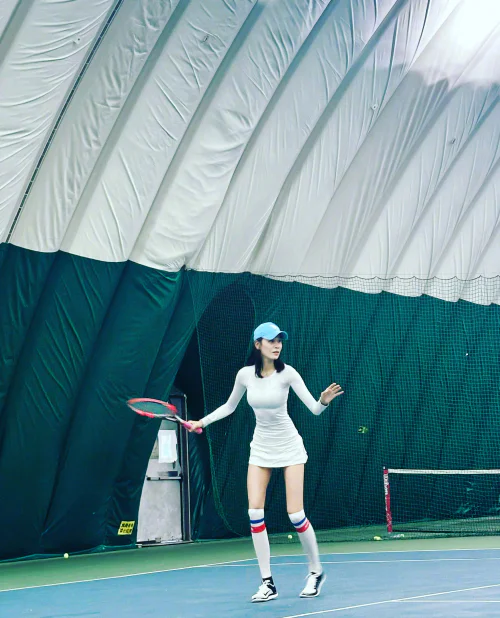 Sporty White Tennis Dress with Blue Cap and Striped Socks for a Chic Court Style
