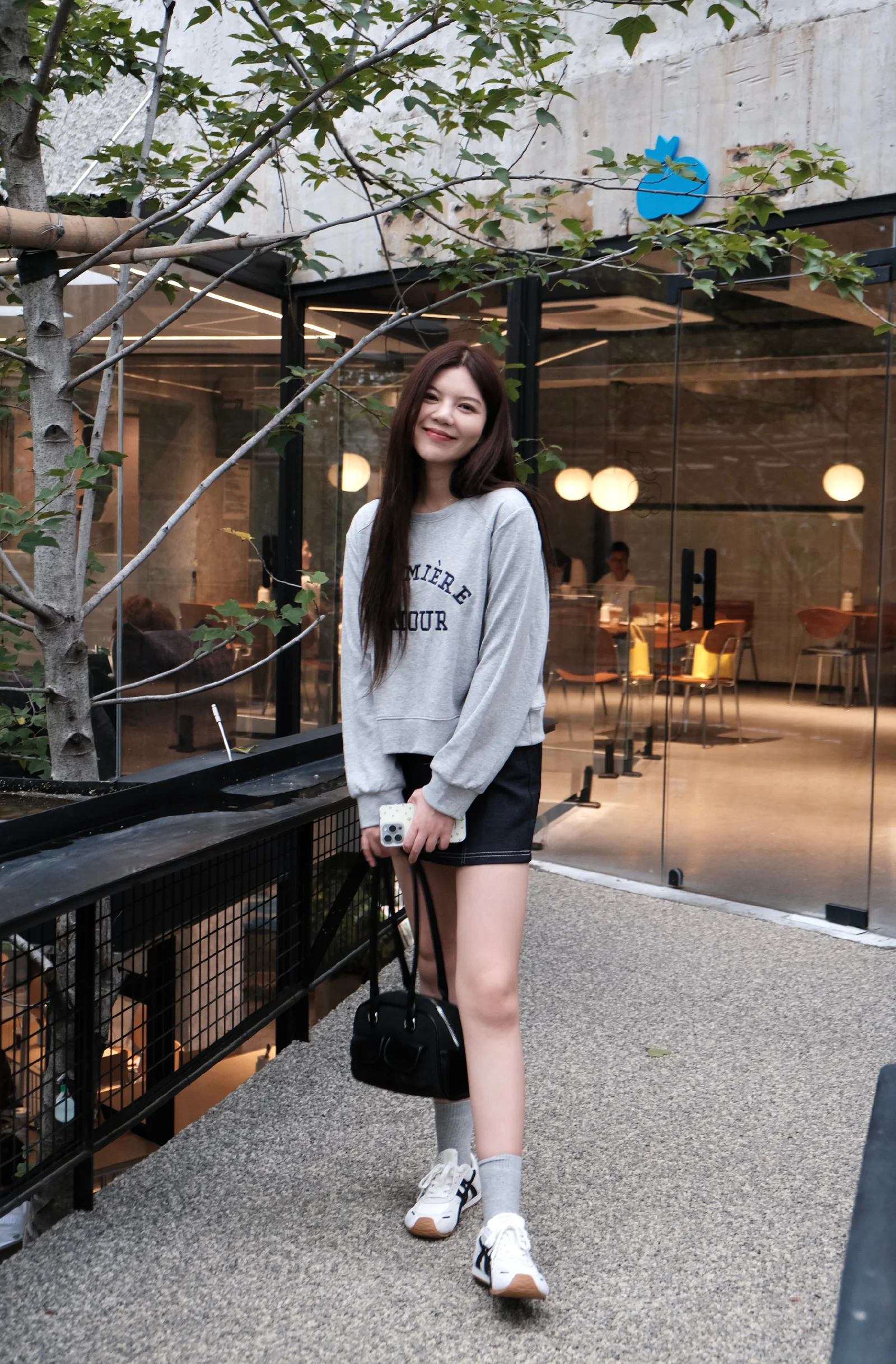 Casual Chic: Gray Sweatshirt and Black Skirt with Sporty Accessories