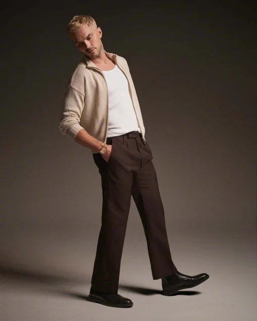 Nicholas Hoult's New Look. Relaxed Sophistication with a Beige Cardigan and Dark Trousers